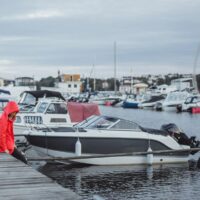 yacht al molo donna con mantello rosso e salvagente