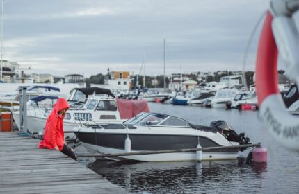 yacht al molo donna con mantello rosso e salvagente